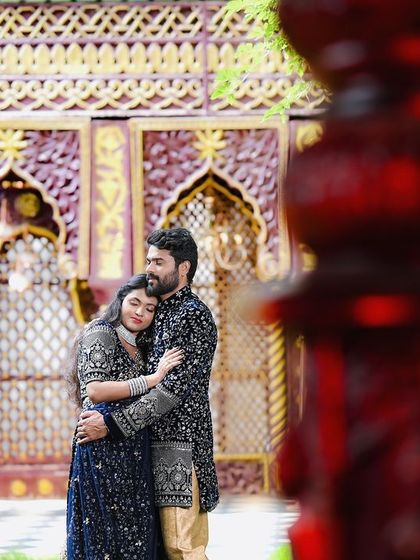 A creative, framed shot of a couple in a royal, dark wood setting.