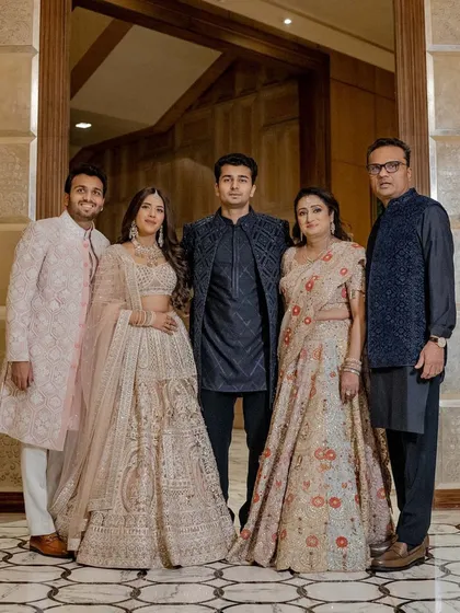 A beautiful family portrait that captures the harmony of our styling. The soft blush and beige tones of the bride, groom, and mother are elegantly contrasted by the deep blue ensembles of the father and brother. This thoughtful color coordination ensures every family photo is a masterpiece.