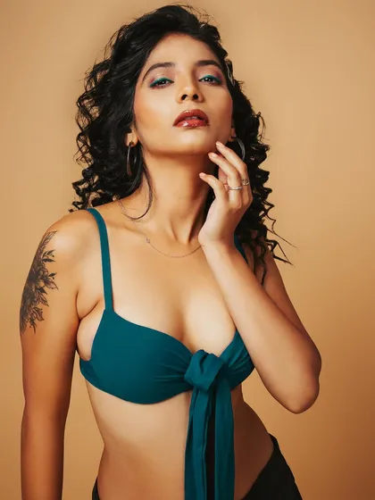 A vibrant swimwear shoot with a focus on creative makeup. The teal bikini top is complemented by the pop of color in the eyeshadow, creating a fresh and edgy look for a model's book.