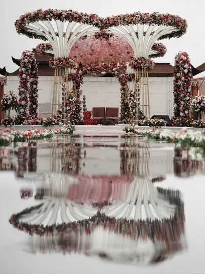 The stunning reflection of a grand floral mandap in the water, creating a perfectly symmetrical and artistic composition. This shot highlights my eye for detail and ability to capture the beauty of wedding decor in a unique way.