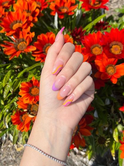A bright and summery abstract design with swirls of orange and purple, shown against a backdrop of vibrant flowers.