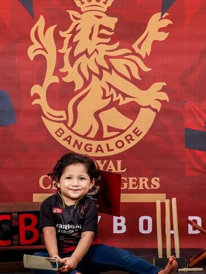 Another great shot from our RCB cricket theme. This little fan is all smiles, ready to play bold with his mini cricket bat and stumps.