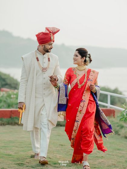 The couple walks hand-in-hand along the coast, a beautiful portrait from their dream beach wedding.
