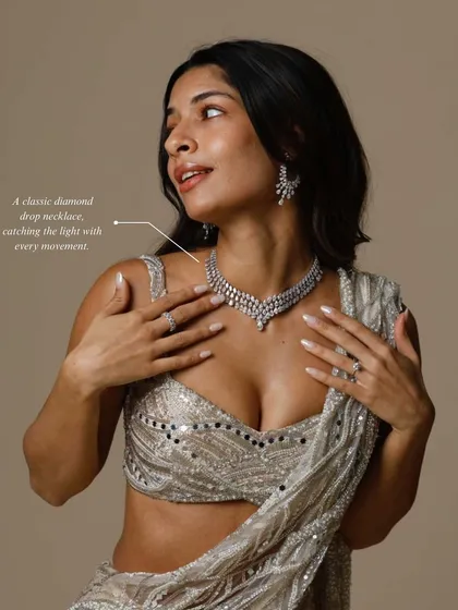 A classic diamond drop necklace catching the light with every movement. It's the perfect elegant touch for a reception or engagement party.