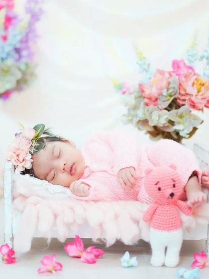 A classic newborn portrait in a miniature bed, surrounded by flowers. This setup makes it look like your baby is a tiny fairy sleeping in a garden.