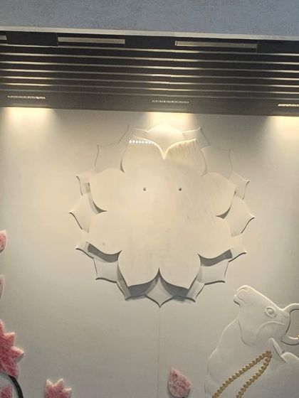 A spiritual-themed mural featuring a lotus and Nandi, carved in stone with delicate coloring. We specialize in creating custom pieces for sacred spaces.