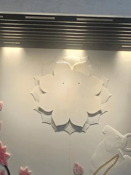 A spiritual-themed mural featuring a lotus and Nandi, carved in stone with delicate coloring. We specialize in creating custom pieces for sacred spaces.