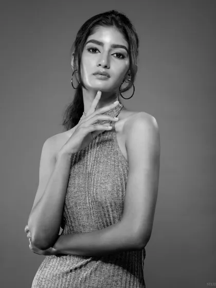 A thoughtful black and white portrait. The three-quarter shot with a simple pose creates a classic and professional headshot.