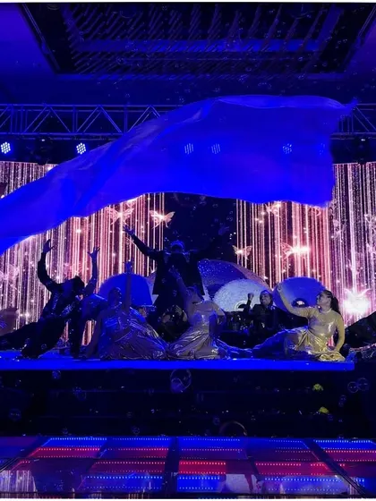 A dramatic moment from the bride's solo, using a large blue fabric prop to create a stunning visual effect.
