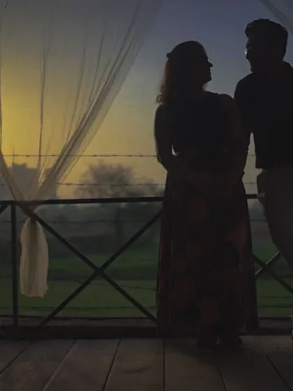 Using the early morning light to create a powerful silhouette. This pre-wedding photo captures a quiet, intimate conversation between the couple against a sunrise, symbolizing a new day and a new life together.