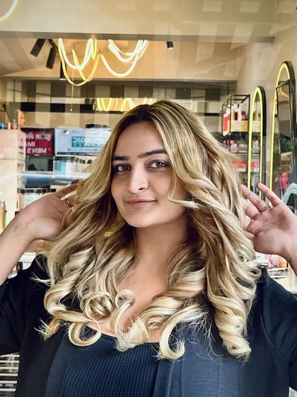 Another shot of the client enjoying her fresh blonde hair. The multi-tonal highlights and expert styling create a look that is both glamorous and effortlessly chic.