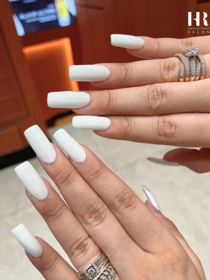 A bold and clean statement with long, square-shaped extensions. A flawless application of opaque white gel polish creates a crisp, modern, and high-fashion look.