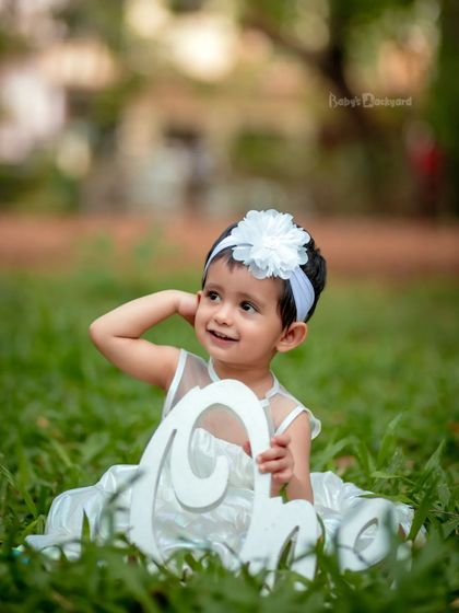 The sweetest little bundle of joy. An all-white outfit looks so angelic against the green grass.
