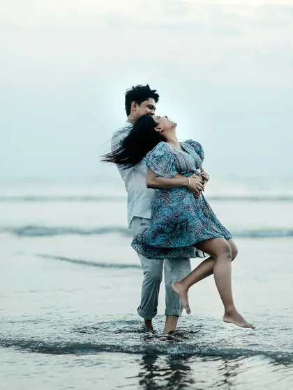 A playful lift in the waves. This shot is full of joy and energy, perfect for a fun-loving couple's pre-wedding album.