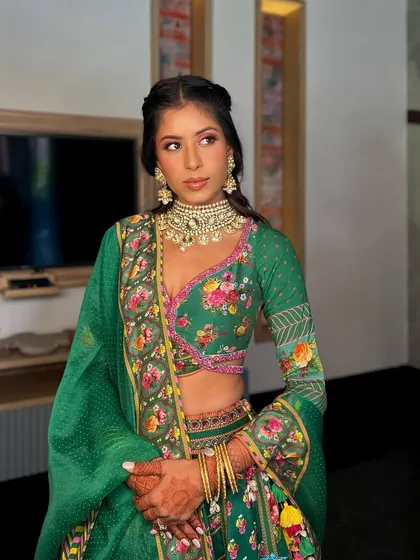 A side profile showcasing the details of this beautiful green Mehendi outfit and the complementary makeup. The focus is on radiant skin and softly defined eyes.