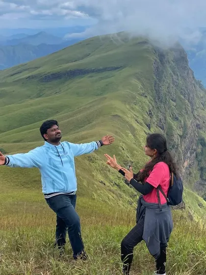 A playful moment between two trekkers on the summit.