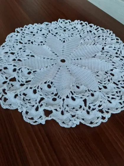 The 15-inch doily displayed on a wooden table, showing how it looks as a centerpiece.