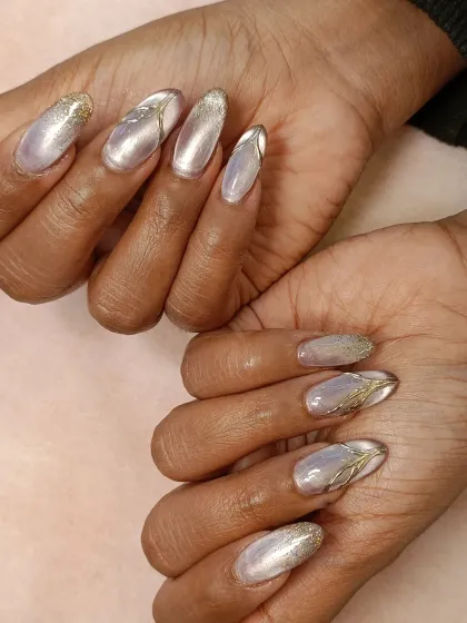 A full view of both hands, showing the complete cat-eye and chrome nail set. This design is a great example of mixing different metallic and glitter textures for a cohesive look.