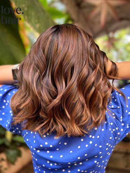 The back view of our 'iced caramel macchiato' balayage, showing how the highlights are concentrated on the mid-lengths and ends for a natural, sun-kissed effect.