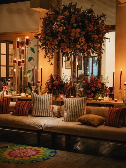 A cozy lounge area at one of my events, with plush cushions, tall candelabras, and a stunning floral centerpiece. I curate the entire vibe, not just the food.