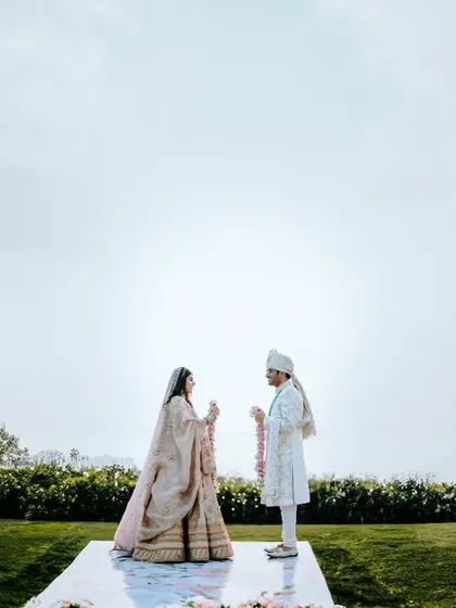 A minimalist and serene shot of the couple during their outdoor ceremony, with the vast sky as their witness. This highlights our ability to capture beauty in simplicity.