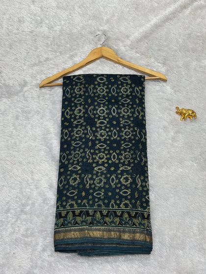 A beautiful Bagru printed saree in Chanderi silk. The deep teal color is complemented by intricate traditional block prints and a zari border, making it a sophisticated choice.