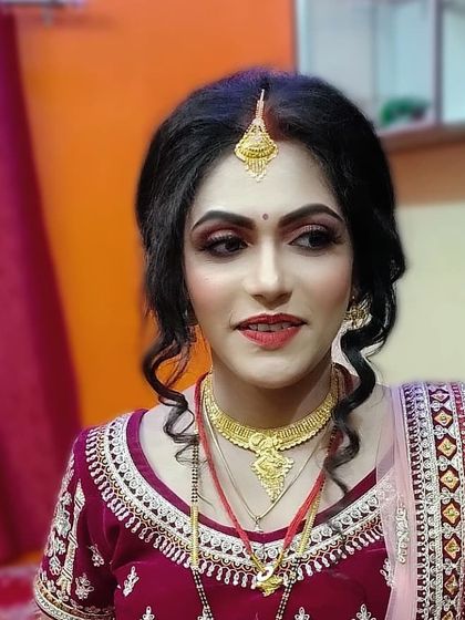 A soft and romantic look for an engagement or sangeet ceremony. The hair is styled in loose curls, and the makeup is kept fresh and radiant with a pop of color on the lips.