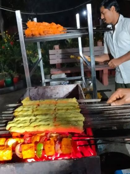 We cater to everyone. Here you can see our vegetarian Paneer Tikka grilling alongside non-veg seekh kebabs, ensuring all your guests have delicious, fresh options.