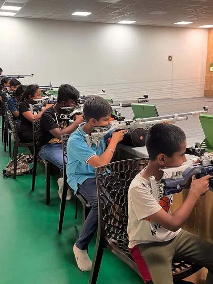 Students practice shooting from a seated position. This technique is valuable for building stability and adaptability, key skills for any marksman.