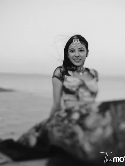 A soft, dreamy black and white portrait of the bride on a beach in Kenya. Her happy, relaxed expression captures the peaceful and joyful atmosphere of her destination wedding.
