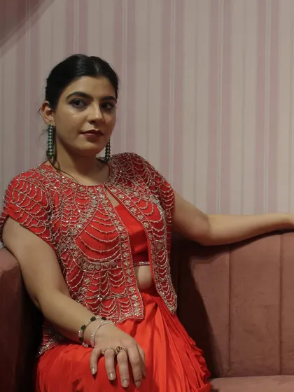 Me, sitting pretty in our red draped skirt set with the hand-embroidered jacket.