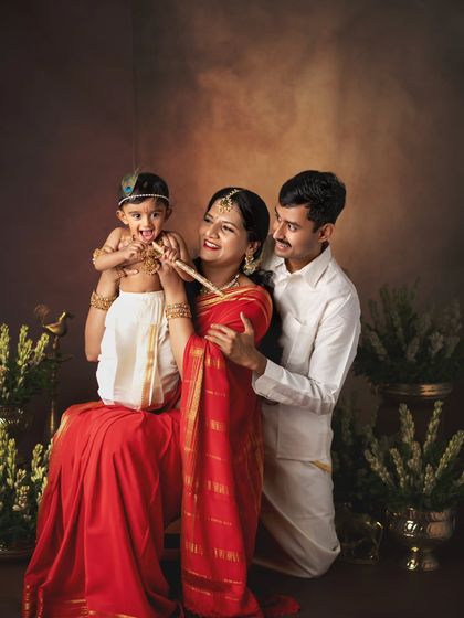 A beautiful family portrait from a Krishna Janmashtami session. The traditional clothing and classic backdrop create a timeless image.