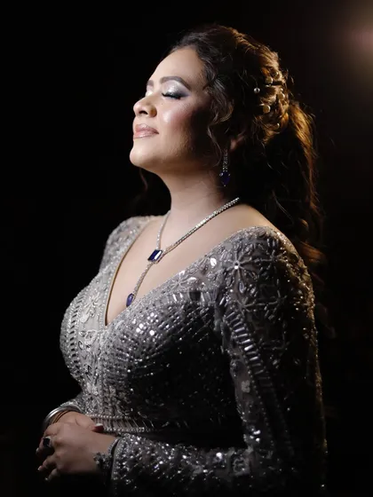 A beautiful profile shot, highlighting the shimmering eyeshadow and flawless skin.
