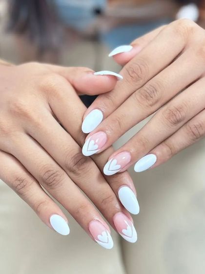 The full two-hand view of this lovely and modern heart manicure. The balance between the solid white and the accent nails is perfect.
