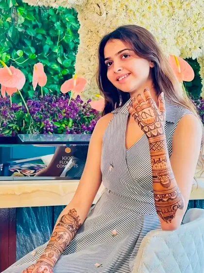 A smiling client with her personalized engagement mehndi.