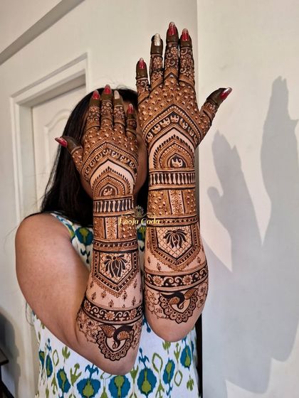 A stunning back-of-hand design that extends up the arm. This piece features intricate patterns with peacocks and lotus motifs, perfect for showing off during wedding ceremonies and photo sessions.