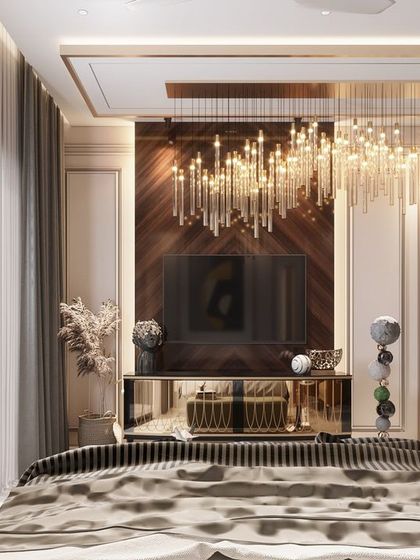 A truly luxurious master bedroom featuring a dramatic, cascading chandelier over the bed. The mirrored TV unit and floor-to-ceiling windows with a balcony view add to the sense of opulence and grandeur in this high-end residential design.