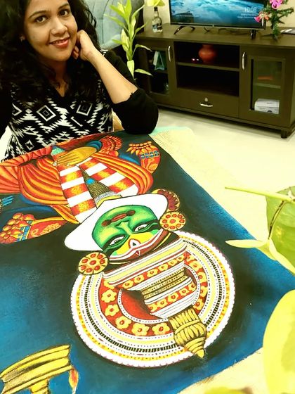 Taking a moment with my Kathakali painting. The deep blue background makes the character's green face and red-and-white costume stand out.