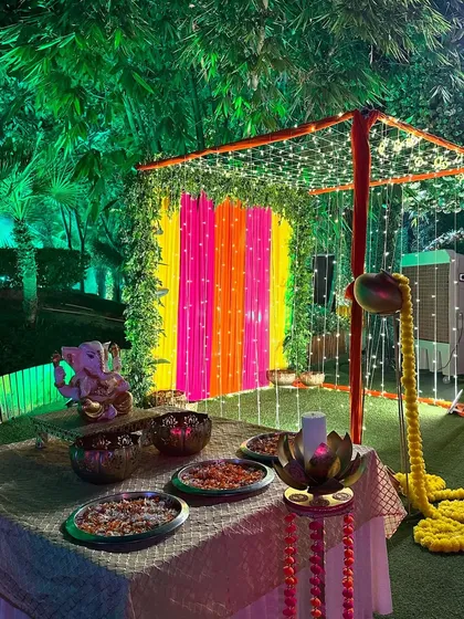 A colorful outdoor setup for a Diwali party. We created a small canopy with bright drapes and fairy lights, with a Ganesha idol and a table for prasad.