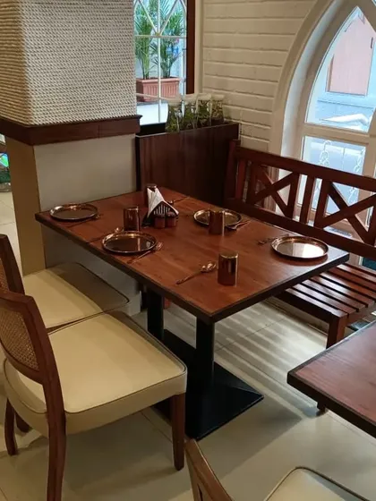 A cozy corner in the restaurant featuring a mix of my custom-made chairs and a wooden bench. This shows how I can create a variety of seating styles for a single project to add visual interest.