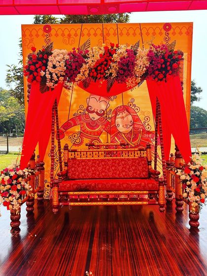 A beautiful seating area from the Rajasthani Mela, featuring a traditional swing against a custom-painted backdrop of a royal couple.