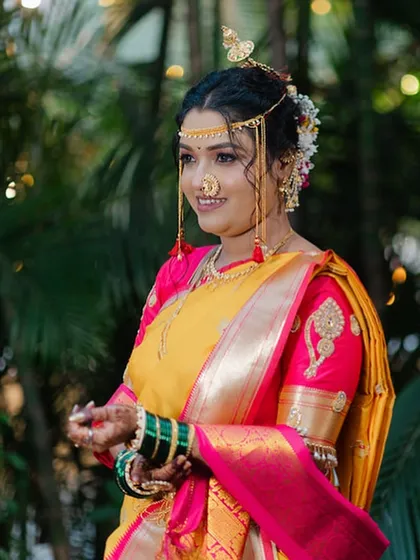 A three-quarter portrait of the bride, showcasing her complete look from her hairstyle to her saree.