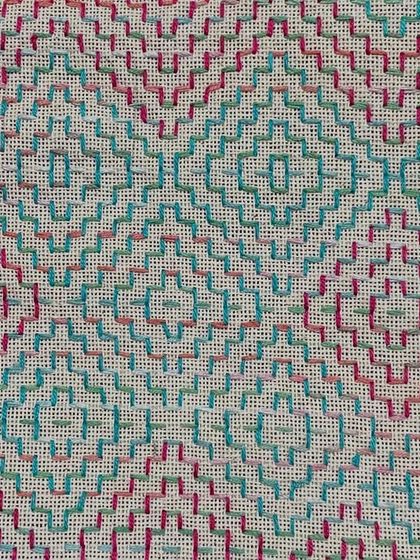 A close-up of the fabric used for the spectacle case, showing the intricate counted thread pattern.