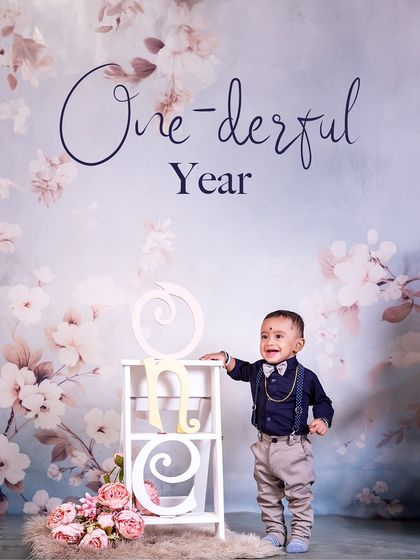 Standing tall and proud to be one! This little boy's charming smile and dapper outfit are the centerpiece of this beautifully simple and elegant first birthday portrait.