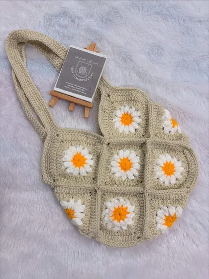 I love making these granny square daisy bags. This one, in a lovely neutral beige, is perfect for a breezy, boho-chic look. It's lightweight, made from 100% cotton yarn, and adds a touch of handmade charm to any outfit.