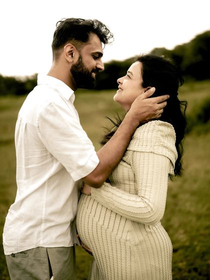 An intimate portrait of the couple embracing. He gently holds her face as they look at each other, a moment filled with tenderness and love.