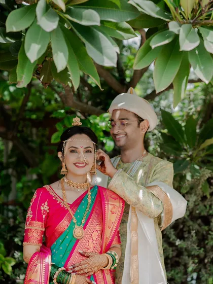 A sweet moment between a Maharashtrian bride and groom, as he helps her with her jewelry during their wedding ceremony.