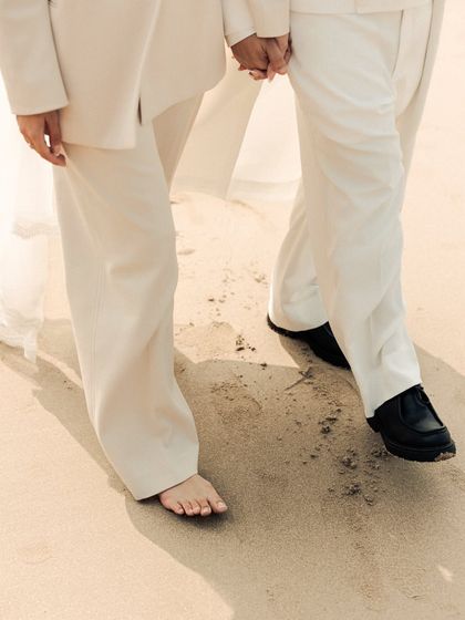 The simple act of walking barefoot on the sand, together. This detail shot captures the feeling of being grounded and connected, both to each other and to the earth, during their serene beach wedding.