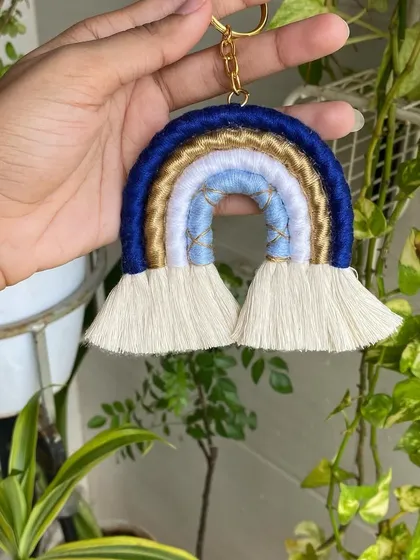 This handmade macrame rainbow keychain features shades of blue and gold. We can create these in any color combination you like to match your personal style.