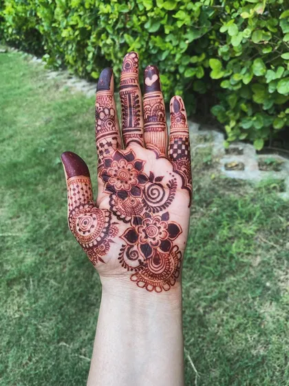 The beautiful, dark stain on this floral design shows the amazing results of good aftercare. The color is deep and even across the entire hand.